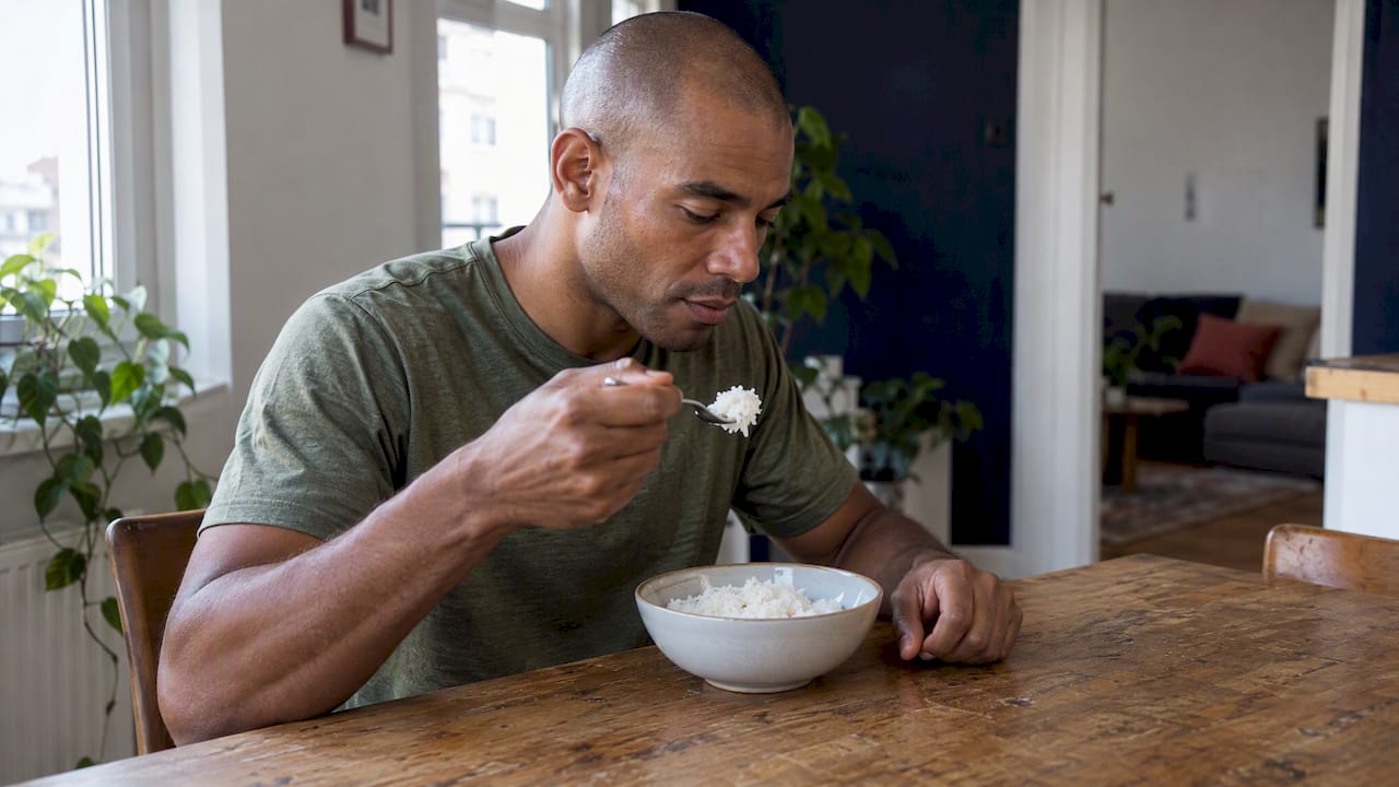 Un coureur mangeant du riz blanc avant sa course