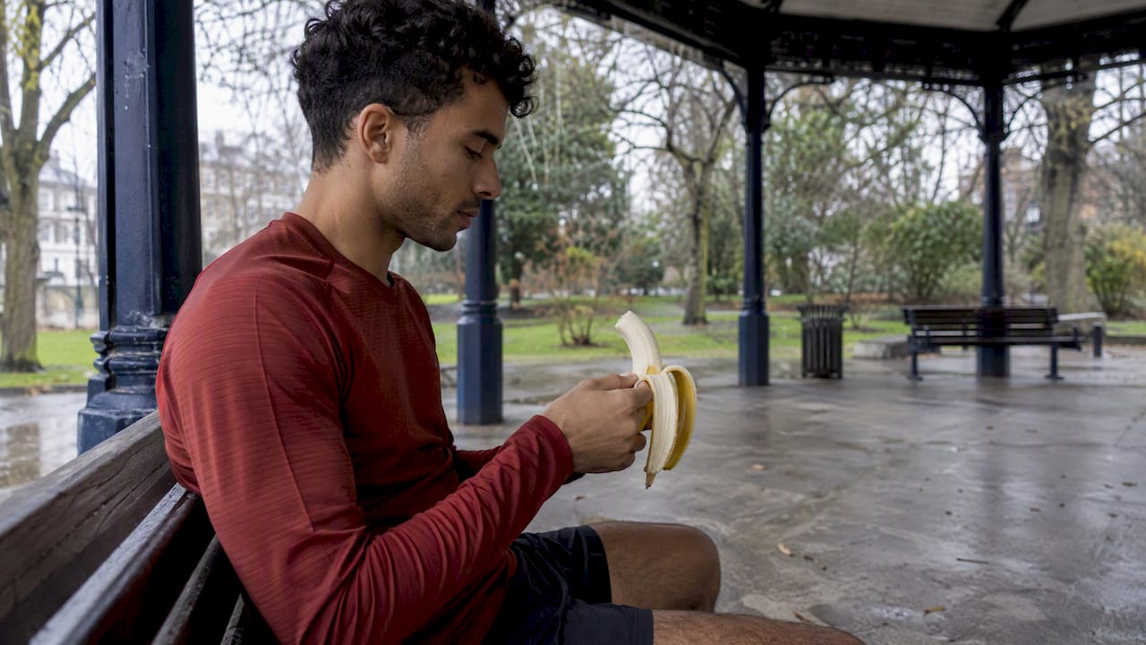 Un coureur mange une banane avant sa sortie